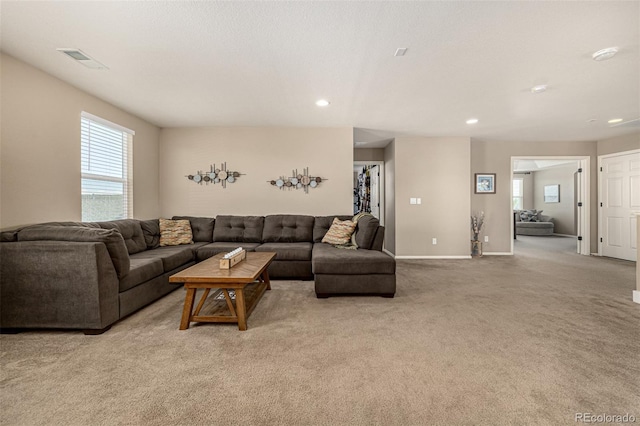 living room featuring light colored carpet, plenty of natural light, recessed lighting, and baseboards