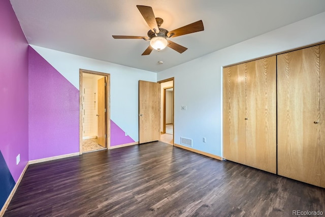 unfurnished bedroom with a closet, ceiling fan, dark hardwood / wood-style flooring, and ensuite bath