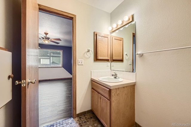 bathroom featuring hardwood / wood-style floors, vanity, ceiling fan, and a textured ceiling