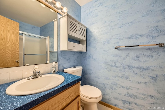 bathroom featuring vanity, toilet, walk in shower, and backsplash