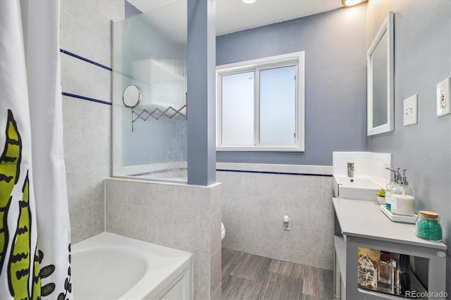 882 E Briarwood Cir, Centennial, CO 80122 - bathroom featuring vanity, a bathing tub, toilet, tile walls, and wood finished floors