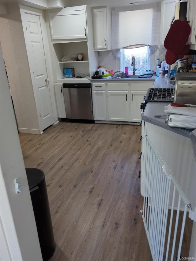 kitchen featuring dishwasher, white cabinets, sink, light hardwood / wood-style flooring, and decorative backsplash