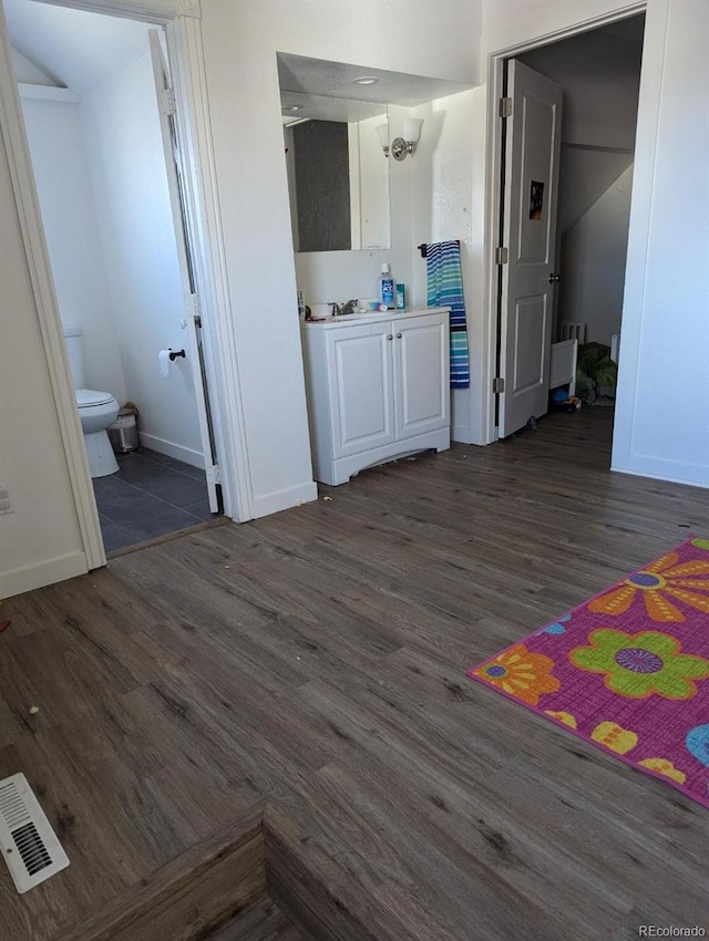 bathroom with hardwood / wood-style floors, vanity, and toilet