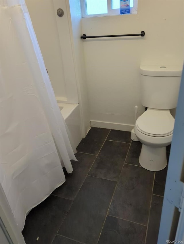 bathroom with tile patterned floors, shower / tub combo with curtain, and toilet