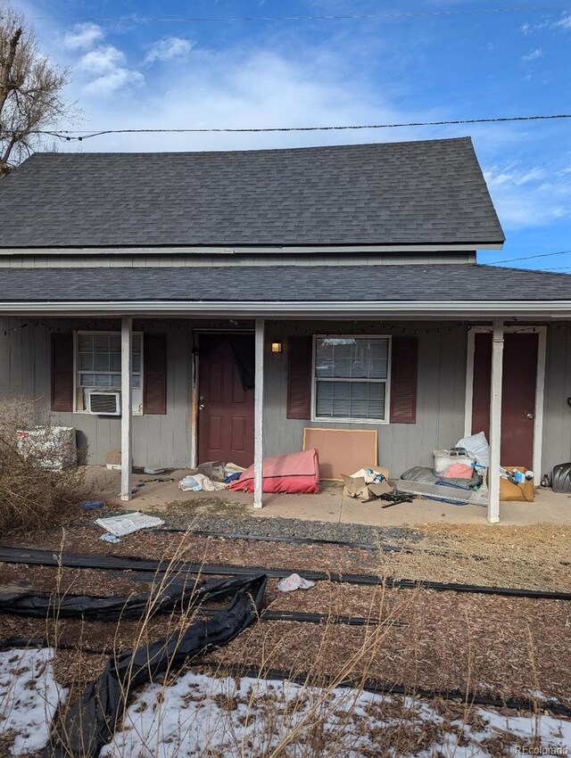 305 Strong St, Brighton, CO 80601 - view of front of house featuring roof with shingles, covered porch, and cooling unit