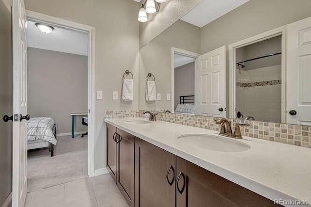 bathroom with tile patterned flooring, double vanity, ensuite bathroom, and a sink