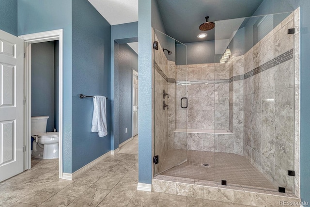 full bath featuring tile patterned flooring, a shower stall, toilet, and baseboards