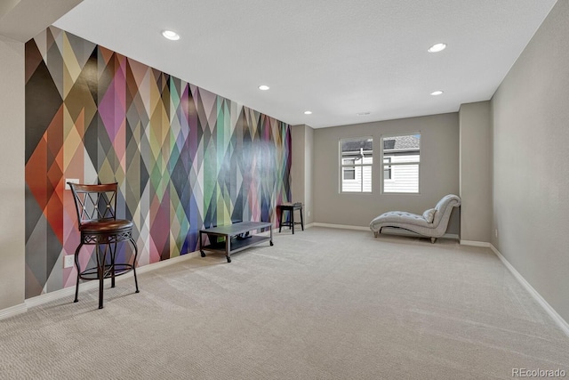 sitting room featuring recessed lighting, carpet floors, wallpapered walls, baseboards, and an accent wall