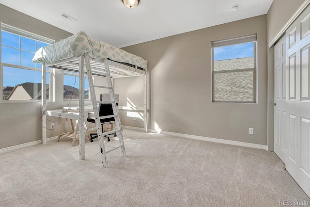 carpeted bedroom with baseboards, visible vents, and a closet