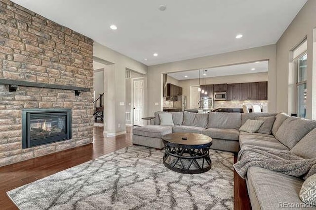 living area with recessed lighting, a fireplace, baseboards, and wood finished floors