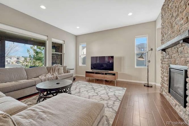 living area with recessed lighting, baseboards, wood finished floors, and a fireplace