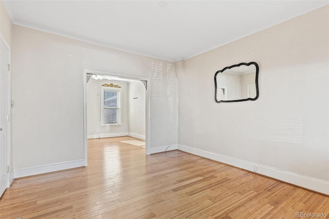 empty room with light hardwood / wood-style floors and crown molding