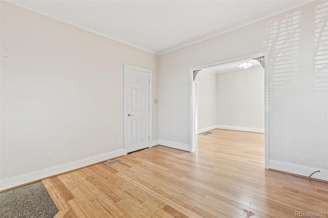 spare room with crown molding and light hardwood / wood-style flooring