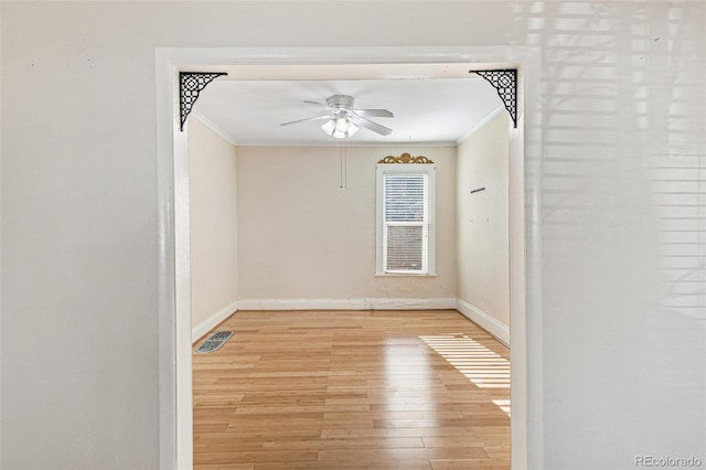 unfurnished room featuring crown molding, ceiling fan, and light wood-type flooring