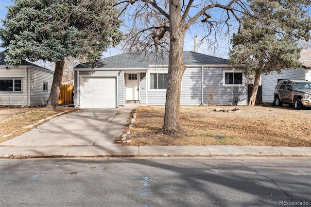 ranch-style home featuring a garage, a shingled roof, driveway, and fence