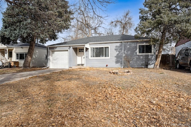 ranch-style home with concrete driveway, fence, and a garage