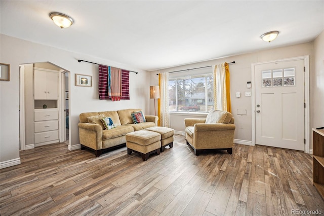 living area with baseboards and wood finished floors