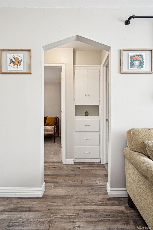 hallway with baseboards and dark wood-style floors