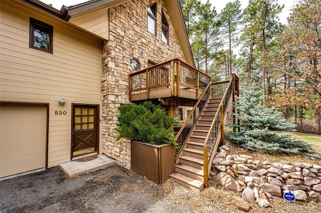 property entrance with a deck and stone siding