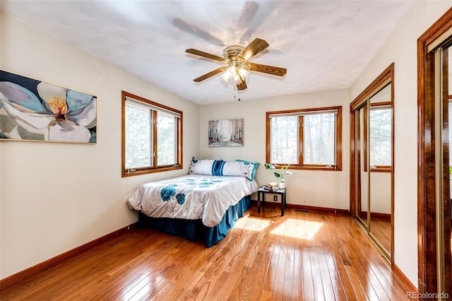 bedroom featuring light wood-type flooring, baseboards, and a ceiling fan