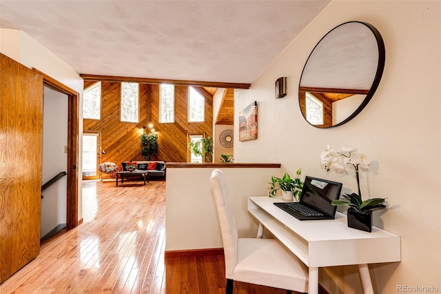 interior space featuring light wood-style floors, wood walls, and baseboards