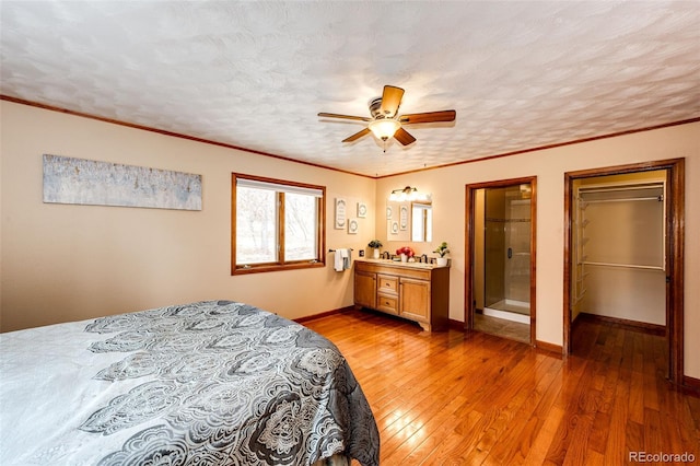 bedroom with light wood-style flooring, a textured ceiling, and ornamental molding