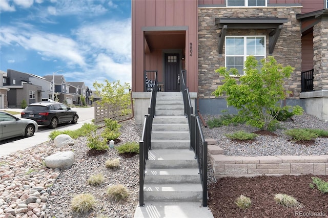9804 Rosalee Peak St, Littleton, CO 80125 - doorway to property featuring stone siding, a residential view, and board and batten siding