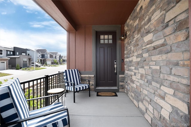 9804 Rosalee Peak St, Littleton, CO 80125 - view of exterior entry featuring a porch, a residential view, board and batten siding, and stone siding