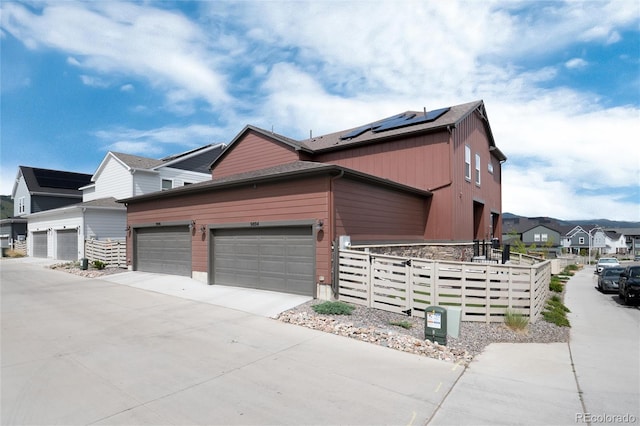9804 Rosalee Peak St, Littleton, CO 80125 - view of side of property featuring solar panels, concrete driveway, and a garage