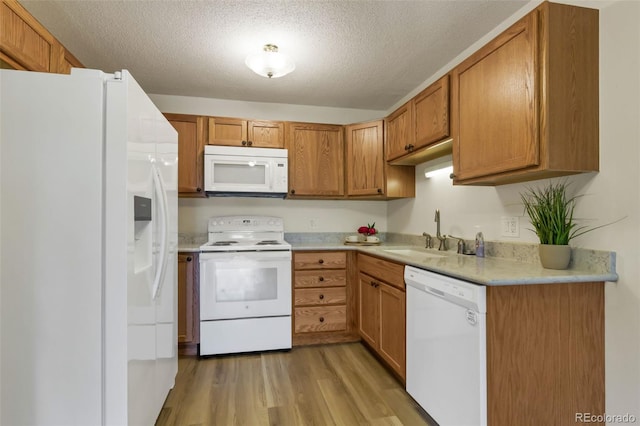 13606 E Bates Ave Unit 304, Aurora, CO 80014 - kitchen with white appliances, a sink, light wood-style floors, light countertops, and a textured ceiling