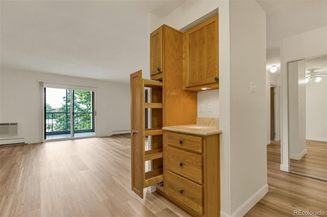 13606 E Bates Ave Unit 304, Aurora, CO 80014 - kitchen with light wood finished floors, light countertops, open floor plan, brown cabinetry, and a wall mounted AC