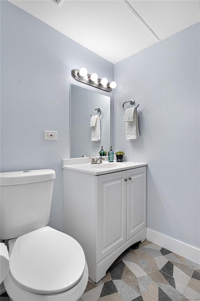 2281 Vaughn Unit 104A, Aurora, CO 80014 - half bath with toilet, vanity, baseboards, and a textured wall