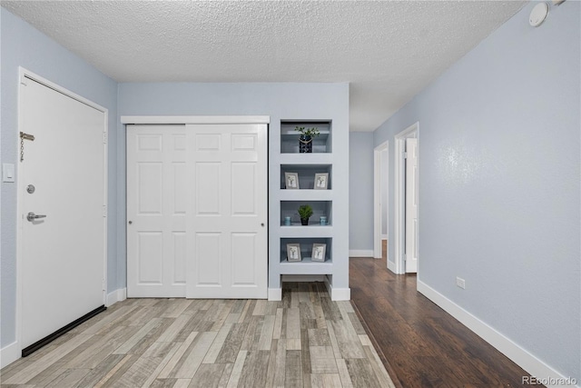 2281 Vaughn Unit 104A, Aurora, CO 80014 - unfurnished bedroom featuring wood finished floors, a closet, baseboards, and a textured ceiling