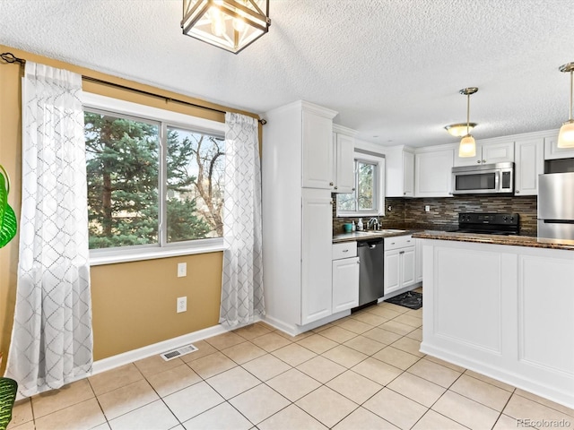 kitchen featuring visible vents, decorative backsplash, dark countertops, appliances with stainless steel finishes, and white cabinetry