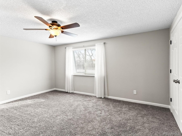 carpeted spare room with ceiling fan, a textured ceiling, and baseboards