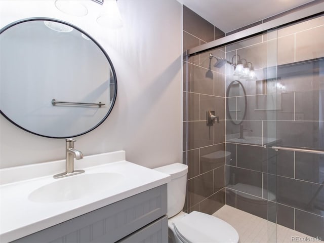 full bath with vanity, a shower stall, and toilet