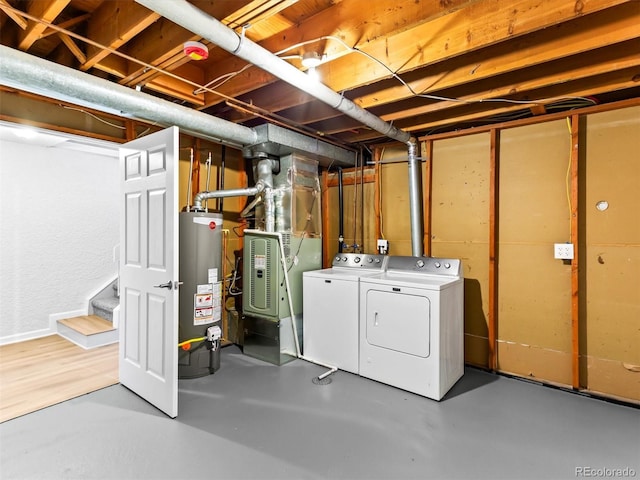 unfinished basement with stairway, gas water heater, and washing machine and dryer