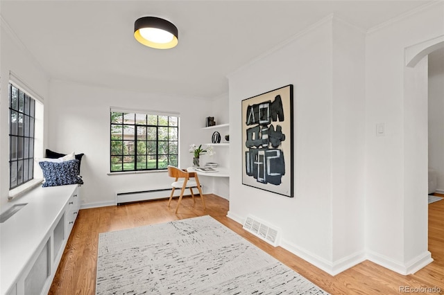 interior space featuring crown molding, light hardwood / wood-style flooring, and a baseboard heating unit