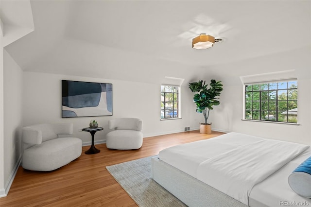 bedroom with vaulted ceiling and hardwood / wood-style floors