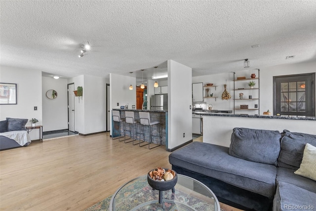 living room featuring light wood-style flooring and a textured ceiling