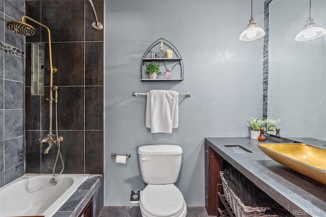 full bath with toilet, vanity, and tiled shower / bath