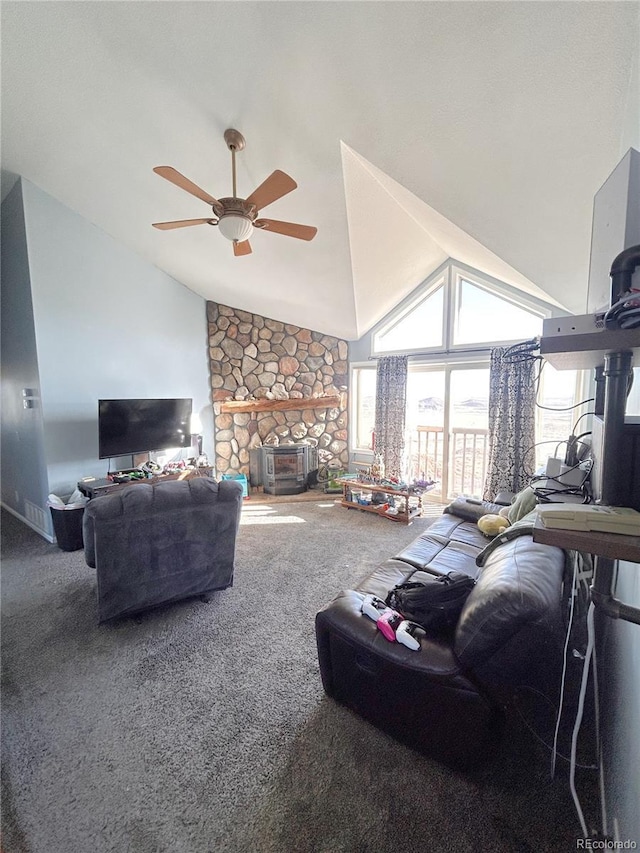 living room with carpet floors, a stone fireplace, ceiling fan, and lofted ceiling