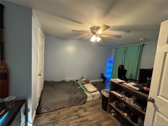 bedroom featuring ceiling fan, wood-type flooring, and a textured ceiling