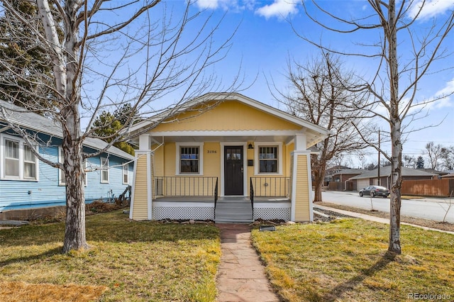 bungalow-style home featuring covered porch and a front yard