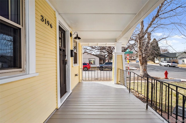 wooden deck featuring a porch and a residential view