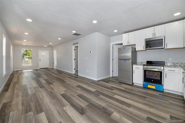 228 E Las Vegas St, Colorado Springs, CO 80903 - kitchen with stainless steel appliances, open floor plan, white cabinetry, wood finished floors, and recessed lighting