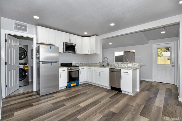 228 E Las Vegas St, Colorado Springs, CO 80903 - kitchen featuring appliances with stainless steel finishes, stacked washer and clothes dryer, dark wood finished floors, a sink, and recessed lighting