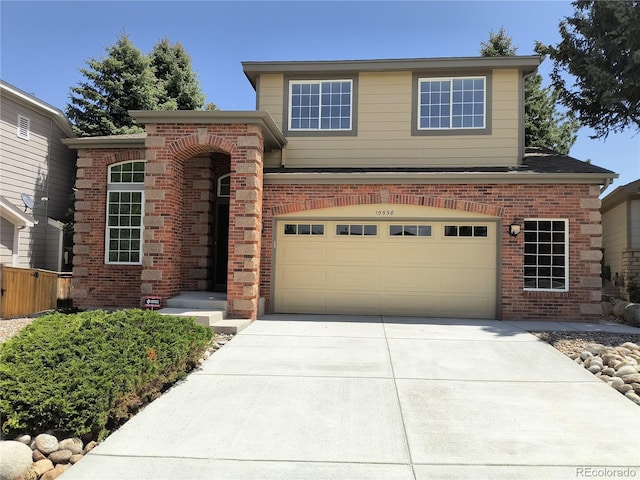 view of front of house featuring brick siding, a garage, and driveway