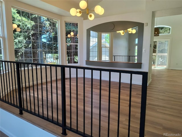 detailed view of a chandelier, wood finished floors, and baseboards