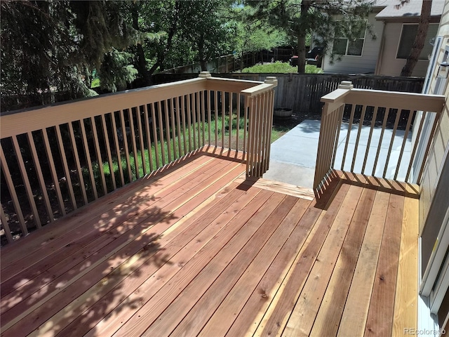 wooden terrace with a fenced backyard